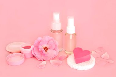 Gül çiçeği kaplıcası, pembe arka planda cilt tedavisi için lüks tedavi ürünleri. Egzama, sedef ve akne cilt hastalıklarını yatıştırır..