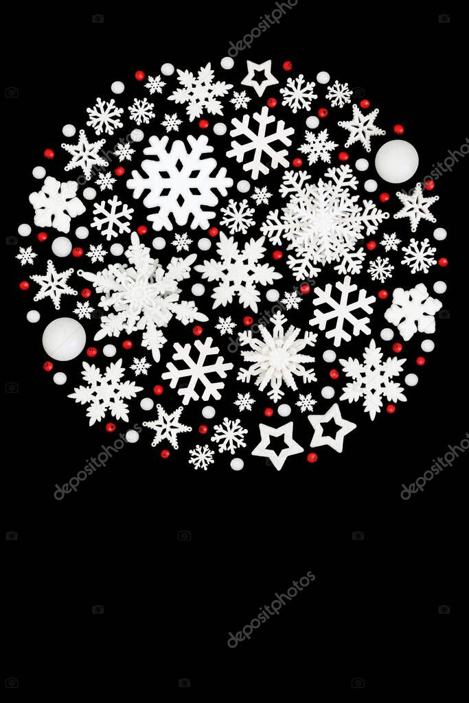 Christmas circle shape decoration, white bauble snowflake, star, ball shape decorations, holly berries on black. Abstract Xmas festive theme.