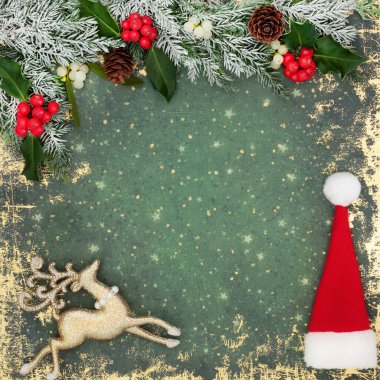 Noel Baba şapkası, ren geyiği ağacı süslemeleri, kutsal kırmızı böğürtlenler, kış çiçekli kar köknarı, grunge yeşil arka plan çerçevesinde ökseotu. Xmas için şenlik tasarımı.