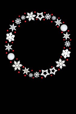 Noel çelengi kırmızı kutsal meyveler, beyaz kar tanesi, yıldız, beyaz arka planda top şeklinde süslemeler. Xmas sezonu için dondurulmuş takı çelengi tasarımı.