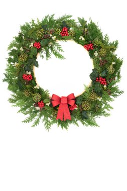 Kış Noel kutsallığı, ökseotu, böğürtlen, sarmaşık, sedir yaprağı flora çelengi, beyaz üzerine kırmızı fiyonk. Gündönümü Xmas Noel için doğal doğa şenlik tasarımı, Yuel. Boşluğu kopyala.