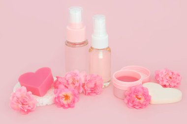 Gül çiçeği spa doğal güzellik tedavisi. Pembe arka planda cilt tedavisi için lüks tedavi ürünleri. Egzama, sedef ve akne cilt hastalıklarını yatıştırır..