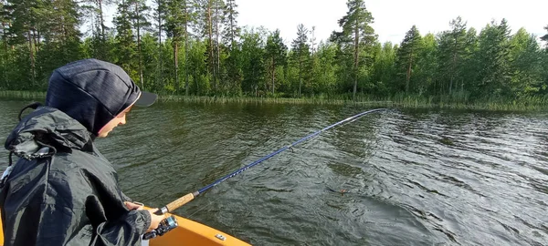 若い漁師はスウェーデンの湖でボートで釣りをしている — ストック写真
