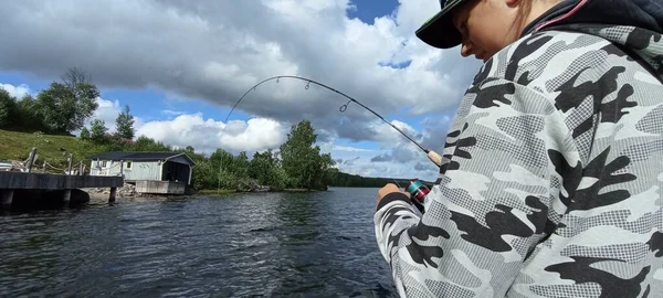 若い漁師はスウェーデンの湖でボートで釣りをしている — ストック写真