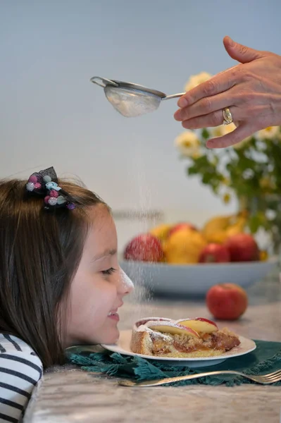 Zabawna Dziewczyna Jedząca Ciasto Jabłkowe Domu Posypane Cukrem Proszku — Zdjęcie stockowe