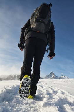Man Walking On Snow With Shoe Spikes In Winter Time