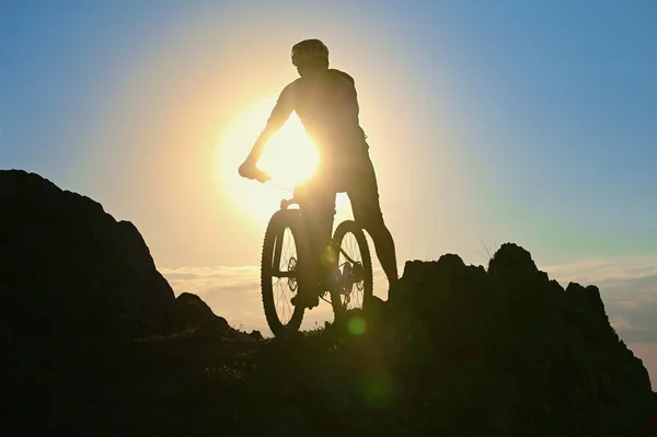 Σιλουέτα Ενός Ποδηλάτη Που Στέκεται Στο Βράχο Ενάντια Στον Ήλιο — Φωτογραφία Αρχείου