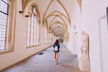 25 Temmuz 2022, Munster, Almanya: Eski bir manastırın kemerinde ya da katedralin avlusunda kız gezgin ve turist