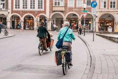 25 Temmuz 2022, Munster, Almanya: Yaşlı bir kadın sağlıklı bir yaşam tarzını sürdürüyor ve Avrupa 'nın bir şehrinde bisiklet yolu üzerinde bisiklet sürüyor