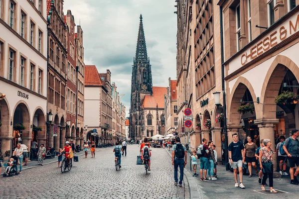 stock image 25 July 2022, Munster, Germany: Prinzipalmarkt - crowds of tourists at famous shopping street and tourist attraction. Saint Lamberti Tower at background.