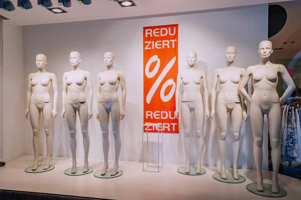 Naked mannequins in the window of a clothing store. The inscription in German - discount.