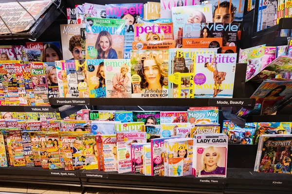 stock image 25 July 2022, Munster, Germany: A lot of fashion magazines, tabloids and high quality journals on the store counter in German