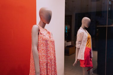 İçinde vitrin ve mankenler olan bir giyim mağazasına giriş. Alışveriş ve moda endüstrisi