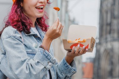 25 Temmuz 2022, Munster, Almanya: Neşeli, mutlu bir kız Nordsee 'de karidesli fast food atıştırıyor.