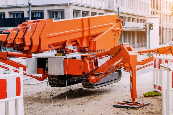 Industrial telescopic unmanned crane standing on hydraulic support legs at a construction site