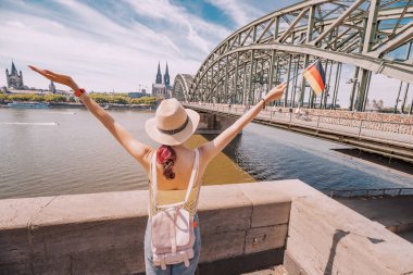 Ren köprüsü ve Köln Dom Katedrali 'ne karşı Alman bayrağı tutan mutlu kız. Seyahat işaretleri ve geleneksel tatiller