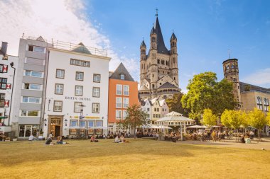 29 Temmuz 2022, Köln, Almanya: Turistlerin kafelerde, renkli evlerde ve Koln 'daki St. Martin Kilisesi' nde dinlendiği balık pazarı meydanı. Seyahat ve gezi.