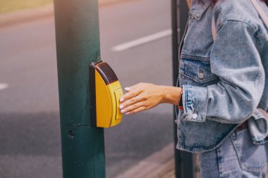 Bilinçli yaya, caddeyi güvenli bir şekilde geçmek için trafik ışığı kontrol düğmesine basar. Kaza azaltma kuralları
