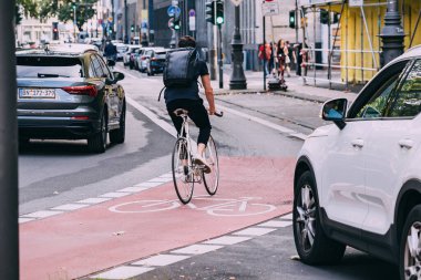 30 Temmuz 2022, Köln, Almanya: Sürücü tehlikeli bir şekilde bisikletlinin yoğun bir caddede sürdüğü bisiklet yoluna yakın fren yaptı.