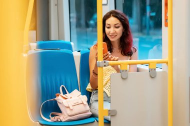 Mutlu kız evine toplu taşıma aracıyla gitmek için akıllı telefonunda bir uygulama kullanıyor.