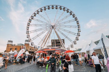 29 Temmuz 2022, Köln, Almanya: İnsanlar ve turistler dönme dolabın yanında dinleniyor. Sokak yemeği festivali. Tatil ve boş zaman