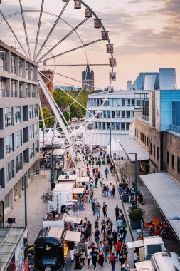 29 Temmuz 2022, Köln, Almanya: İnsanlar ve turistler dönme dolabın yanında dinleniyor. Sokak yemeği festivali. Tatil ve boş zaman