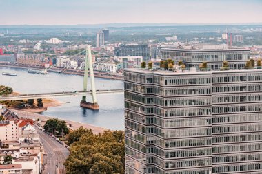 Almanya 'nın Köln şehrindeki Ren nehri üzerindeki hava manzaralı cam gökdelen ve köprü.