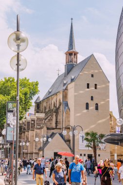 29 Temmuz 2022, Köln, Almanya: İnsanlar güzel Antoniterkirche kilisesiyle yaya caddesinde yürüyor ve alışveriş yapıyorlar