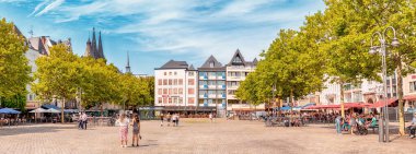 29 Temmuz 2022, Köln, Almanya: İnsanlar Koln 'daki eski bir pazar meydanında kafelerde yürüyüp dinleniyorlar. Şehir hayatı ve şehir gelişimi