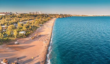 Antalya tatil köyündeki popüler ve manzaralı Konyaalti plajı manzarası. Arka planı sisli görkemli dağlar. Türkiye 'de tatil ve tatil