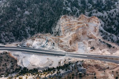 Dağlık bölgelerdeki yol yapımı için ezilmiş taş ocağının hava manzarası. Ekoloji kavramı
