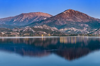 Isparta bölgesindeki Egirdir Gölü ve kasabasının panoramik akşam manzarası. Türkiye 'de turkuaz sakin ve ulusal parkın manzaralı kıyıları