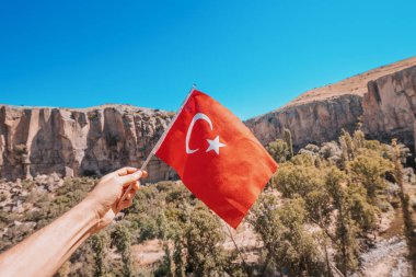 Arka planda Kapadokya 'daki ünlü İhlara vadisi bulunan ulusal Türk bayrağı. Seyahat ve turizm.