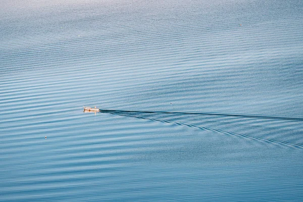 The old man and the sea. Aerial view of a lonely fishing boat on the vast expanses of the sea or lake. Psychological concept