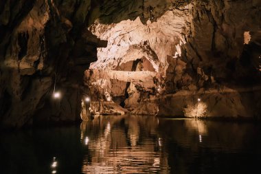 Karanlık mağarada manzaralı bir göl. Speleoloji ve seyahat kavramı