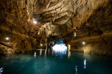 Karanlık mağarada manzaralı bir göl. Speleoloji ve seyahat kavramı