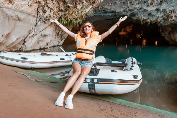 girl at the excursion boat in the cave lake appears to be quite adventurous as she explores the depths of the dark cave and navigates the boat through the winding waterways.
