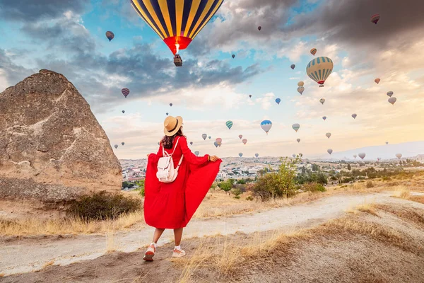 彼女は好きなドレスを着て カッパドキア トルコ 気球からの色の万華鏡で空を見て 彼女の旅行と探検の夢を思い出させます — ストック写真