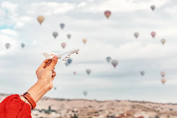 Eine Hand Hält Ein Spielzeugflugzeug Mit Kappadokiens Heißluftballons Hintergrund Das — Stockfoto