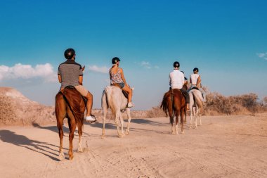 12 Eylül 2022, Kapadokya, Türkiye: Gün batımında at süren bir grup turist