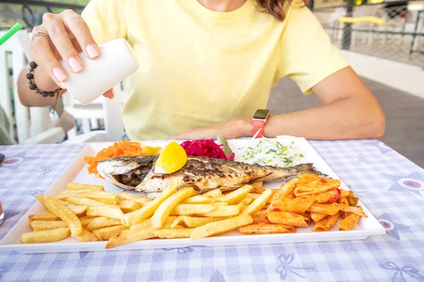 Woman Adds Salt Salt Shaker Baked Trout Fish Restaurant Overabundance — Stock Photo, Image