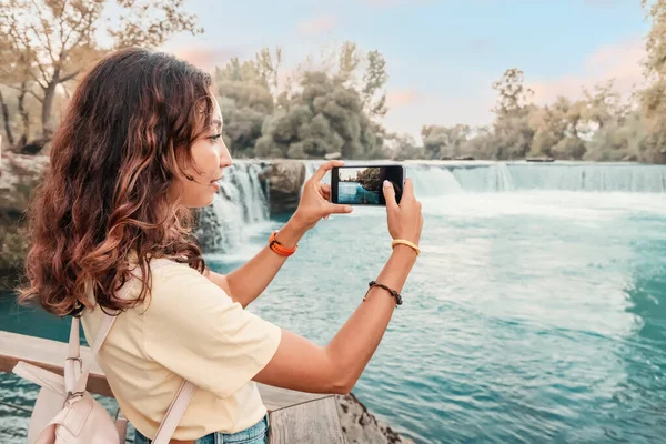旅游博主用他的新昂贵的智能手机拍摄了土耳其著名的马纳瓦特瀑布的高质量而生动的照片 — 图库照片