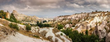 Cappadocia 'nın Güvercin Vadisi' nin nefes kesici panoramik manzarası ve görkemli Uchisar Şatosu mükemmel bir kartpostal olur..