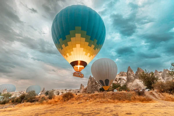 巨大な風船は トルコのカッパドキアのバスケットで観光客と一緒に離陸する前にバーナーで空気を暖めます — ストック写真