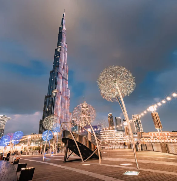 2023年1月18日アラブ首長国連邦ドバイ 有名なブルジュ ハリファ超高層ビルとライトアップされたタンポポの彫刻がアラブ首長国連邦のドバイの遊歩道堤防の夜 — ストック写真