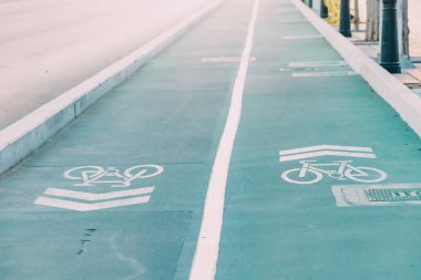 Painted blue Bicycle lane in city park. Eco environment and green and healthy transport. Bike path