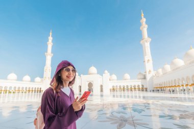 Bir turist kız Abu Dabi 'deki Şeyh Zayed Büyük Camii' nin çarpıcı güzelliğini yakalamak için telefonunu kullanıyor..