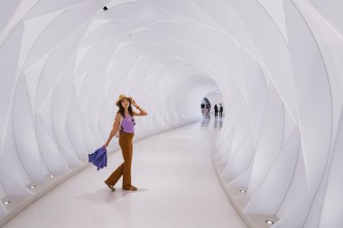 17 January 2023, Dubai, UAE: a girl walks along the passage leading from the metro station to the Museum of the Future in Dubai clipart