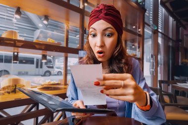 Hint restoranında önünde duran faturaya bakarken kızın yüzü kaşlarını çatmış bir şekilde duruyordu. Keyifli yemeği tatsız bir sürprize dönüşmüş gibi görünüyordu..