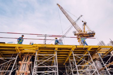17 Ocak 2023, Dubai, BAE: Vinç makineli bir inşaat alanında çalışan işçiler